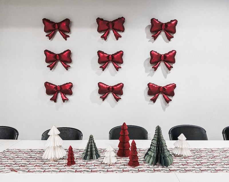 Holiday party table with red bows on the wall at the Events On Main Co. event space in Magna