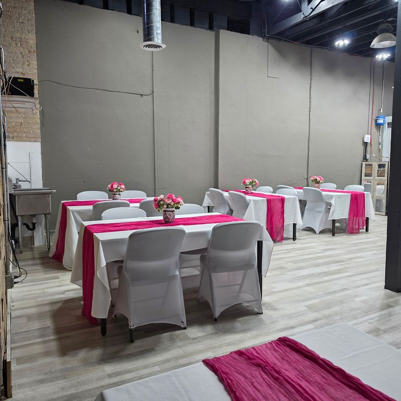 Banquet tables with pink runners and flowers in the Events On Main Co. reception hall in Magna, Utah